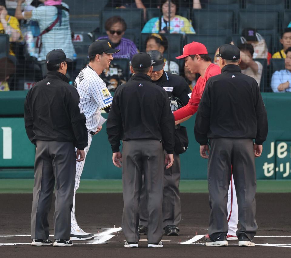 試合前、メンバー表を交換し握手する藤川監督と新井監督（撮影・山口登）