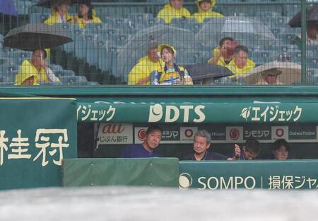 雨が降るグラウンドを見る井上監督（左）＝撮影・西田忠信