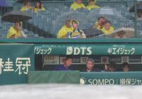 雨が降るグラウンドを見る井上監督（左）＝撮影・西田忠信