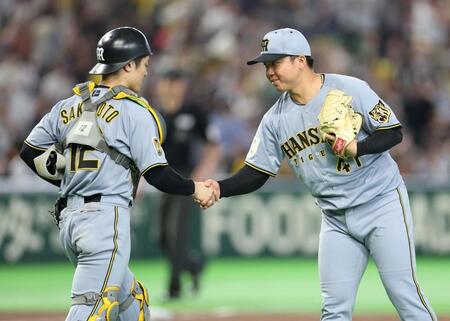 完封勝利を挙げ、坂本（左）と握手を交わす村上（撮影・伊藤笙子）