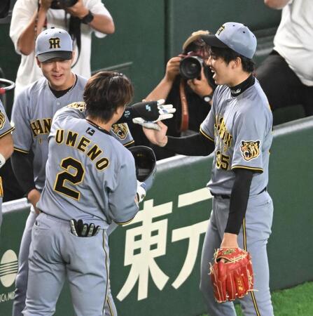 ５回、先制のソロを放った梅野（左）とタッチを交わす才木（撮影・堀内翔）