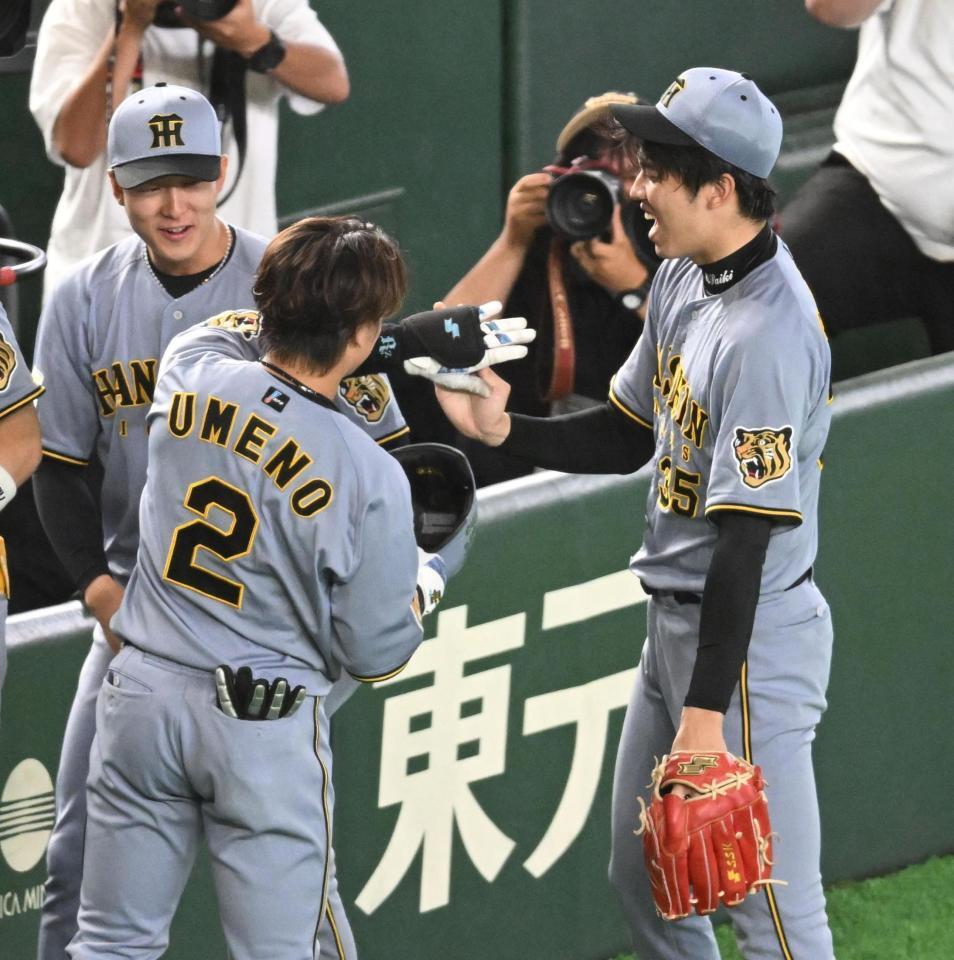 ５回、先制のソロを放った梅野（左）とタッチを交わす才木（撮影・堀内翔）