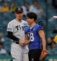 ファーストピッチセレモニーを務めたパナソニックインパルス・桑田理介（右）と握手する佐藤輝（撮影・西田忠信）