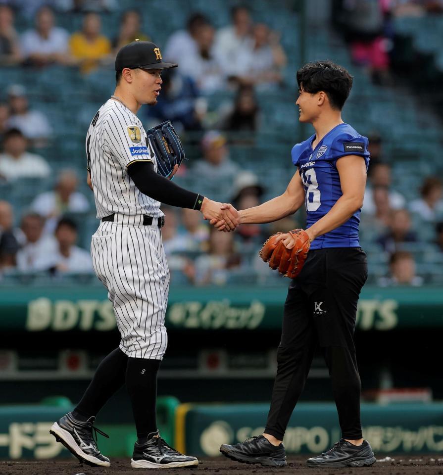 ファーストピッチセレモニーに登場したパナソニックインパルス・桑田理介（右）と握手をする佐藤輝（撮影・西田忠信）