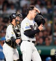 ３回、追加点を許し厳しい表情を見せる木下（左は梅野）＝撮影・山口登