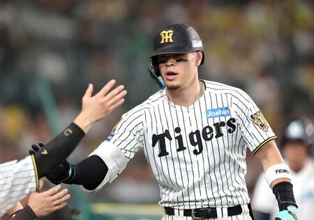 ９回、右越えにソロを放ちナインに迎えられる佐藤輝（撮影・山口登）