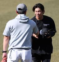 黒木知宏コーチ（左）と握手を交わす梅野（撮影・伊藤笙子）