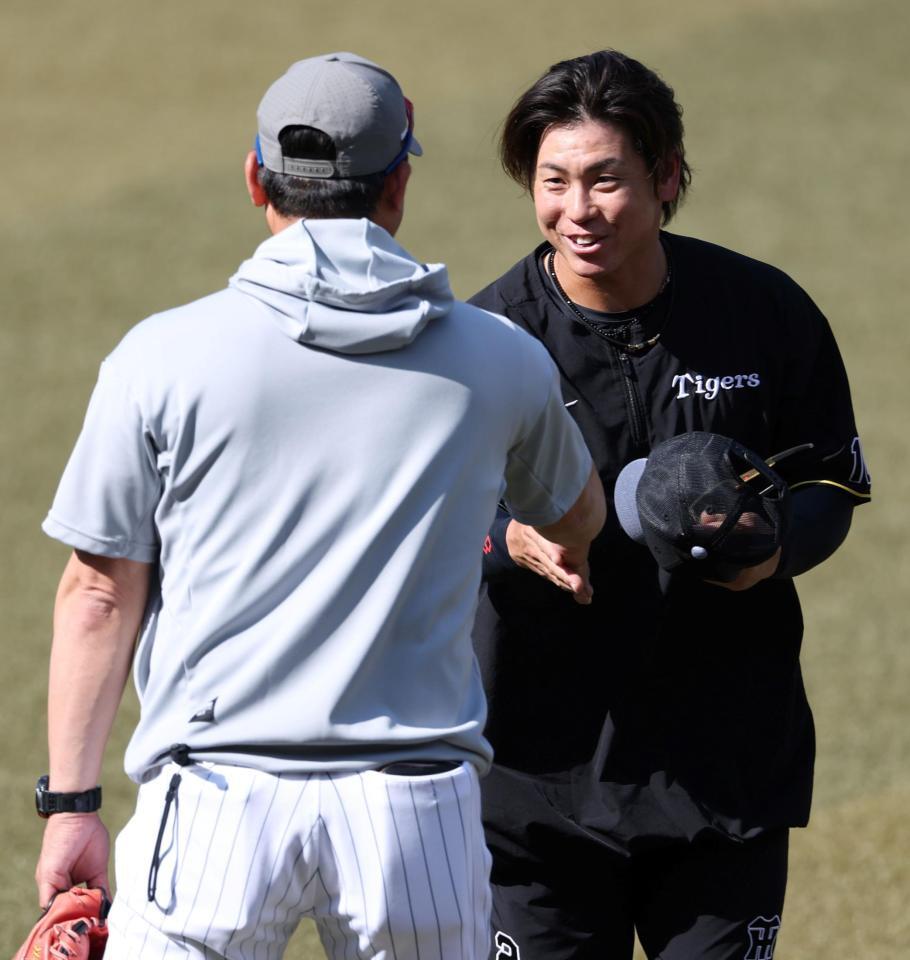 黒木知宏コーチ（左）と握手を交わす梅野（撮影・伊藤笙子）