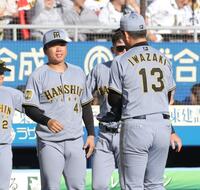 ８回、ピンチを救った岩崎（右）を迎える村上（撮影・西岡正）