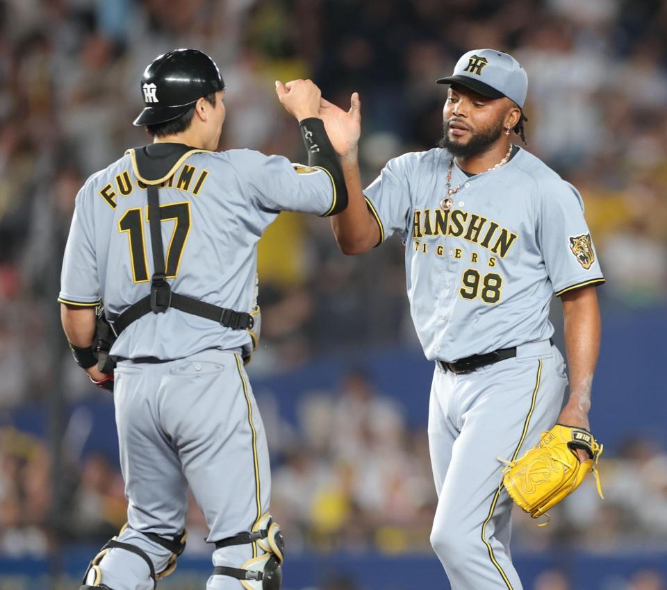 ロッテに勝利し、伏見（左）とタッチを交わすドリス（撮影・西岡正）