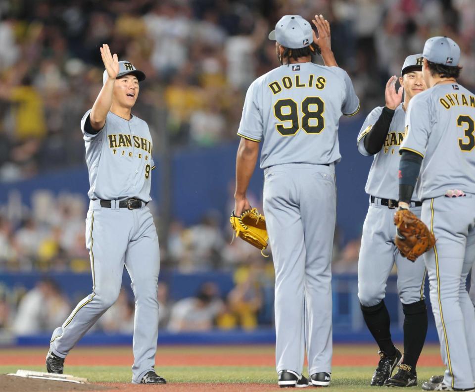 　交流戦初勝利でナインとタッチを交わす立石（左）