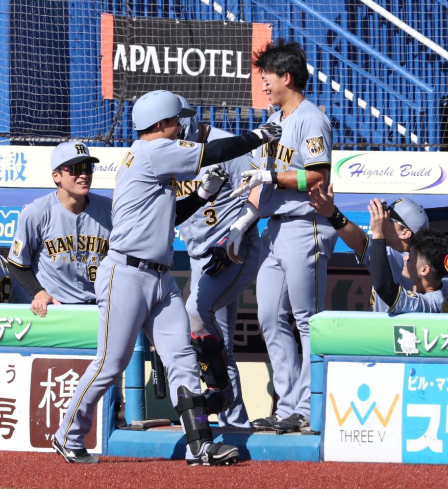 ５回、２打席連発となる左越えソロを放ち、出迎えた立石（中央右）に激励のパンチをする森下（同左）＝撮影・伊藤笙子