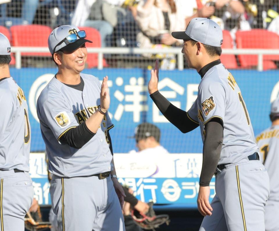 好リリーフの岩崎（右）とタッチを交わす藤川監督（撮影・西岡正）