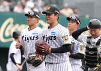 ７回、２死満塁のピンチを凌ぎ、笑顔でベンチに戻る岡留（中央）＝撮影・坂部計介