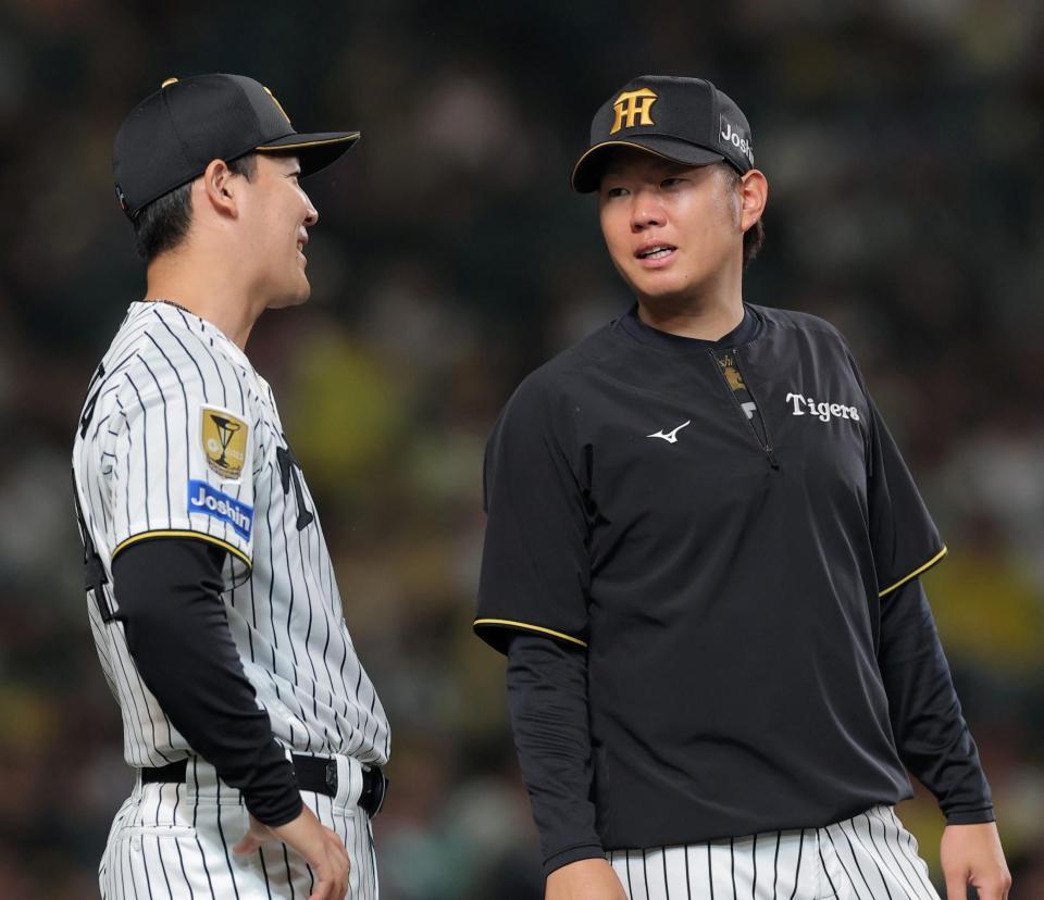 ８回、ベンチ前でナインを迎える木下（左）と西勇（撮影・西田忠信）