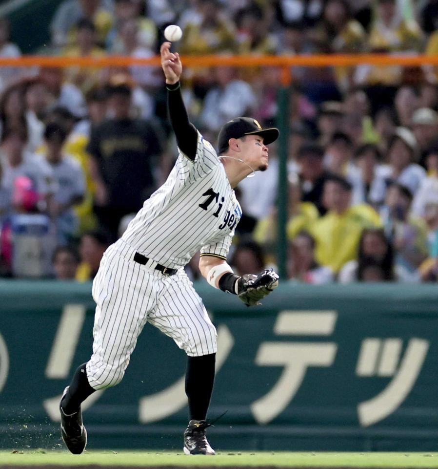 　４回、本塁へ悪送球する佐藤輝（撮影・田中太一）