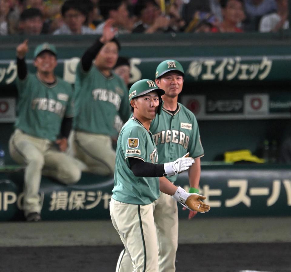 ６回、適時打を放ち、塁上で手を叩く立石（撮影・飯室逸平）
