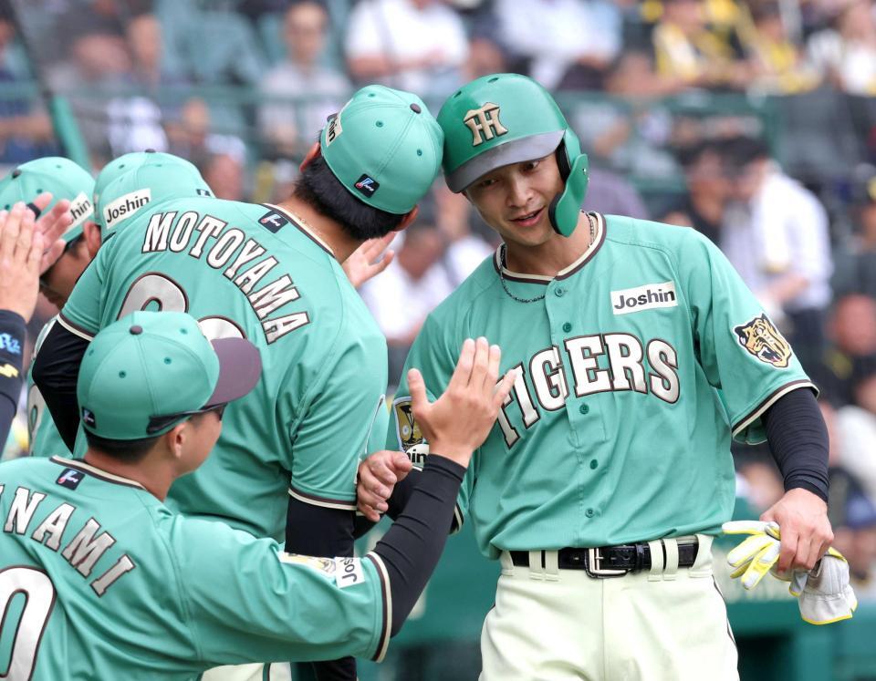 　５回、立石の適時打で生還し、ナインの出迎えを受ける熊谷（右）＝撮影・立川洋一郎