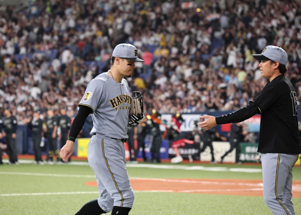 サヨナラ負けを喫し引き揚げる佐藤輝と迎える西勇（撮影・田中太一）