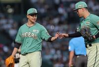 ４回を投げ終え、佐藤輝（右）とタッチを交わす大竹（撮影・西田忠信）