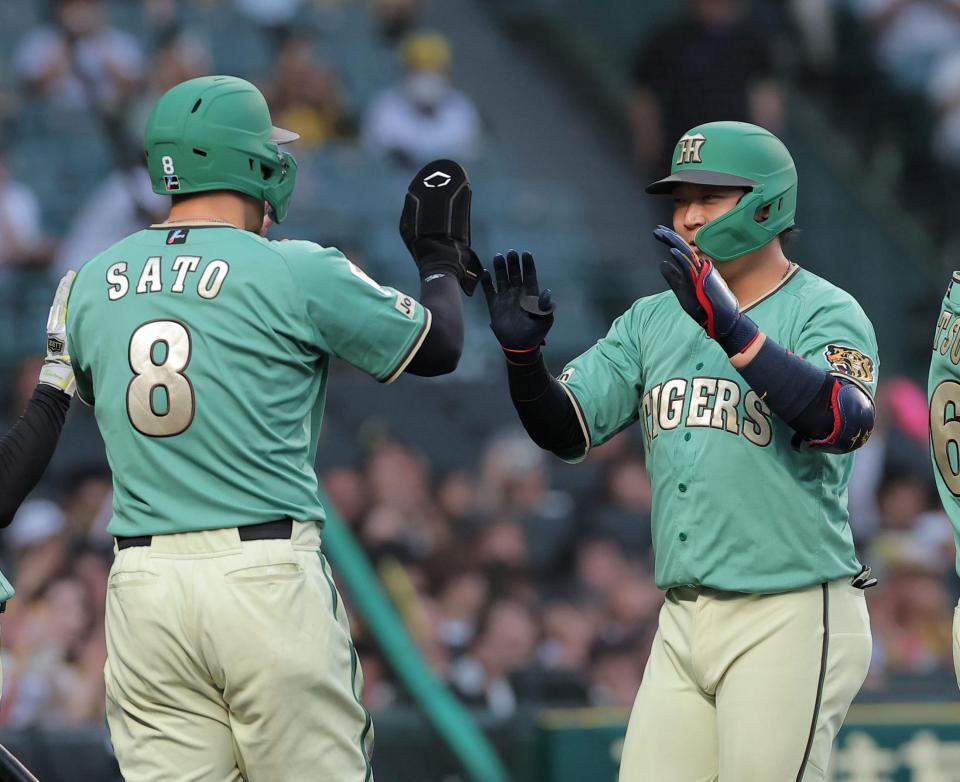 ２回、先制２ランを放ち佐藤輝（左）とタッチを交わす大山（撮影・西田忠信）