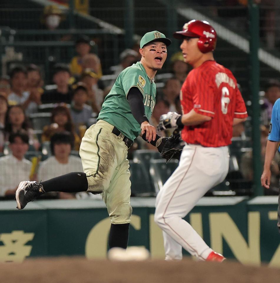 ８回、石原の打球を一塁に悪送球する佐藤輝（左）＝撮影・西田忠信