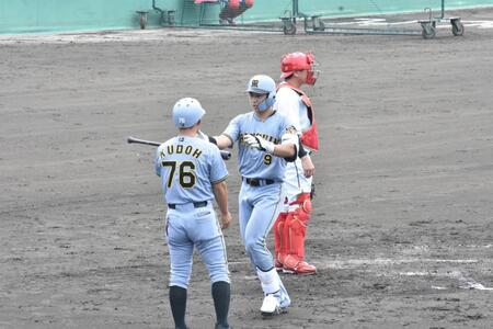 本塁へ生還し、工藤２軍外野守備走塁コーチとハイタッチする立石