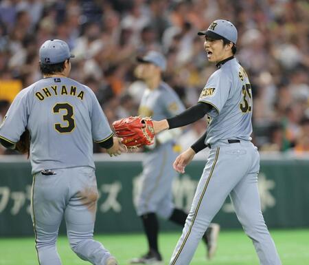 ５回、キャベッジを右飛に打ち取ってピンチを脱し、大山（左）とタッチを交わす才木（撮影・西岡正）