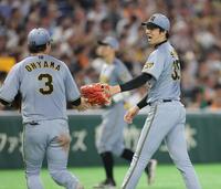 ５回、キャベッジを右飛に打ち取ってピンチを脱し、大山（左）とタッチを交わす才木（撮影・西岡正）