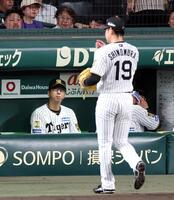 ６回、グラウンドを見つめる藤川監督（右はベンチに戻る下村）＝撮影・山口登