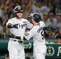 ９回、佐藤輝（左）は生還した近本を迎える（撮影・山口登）