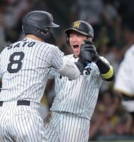 ９回、森下の左前打で生還し佐藤輝（左）と喜ぶ近本（撮影・西田忠信）