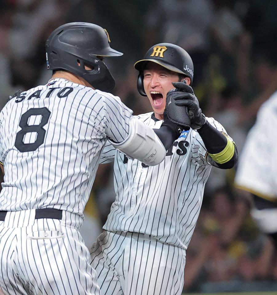 ９回、森下の左前打で生還し佐藤輝（左）と喜ぶ近本（撮影・西田忠信）