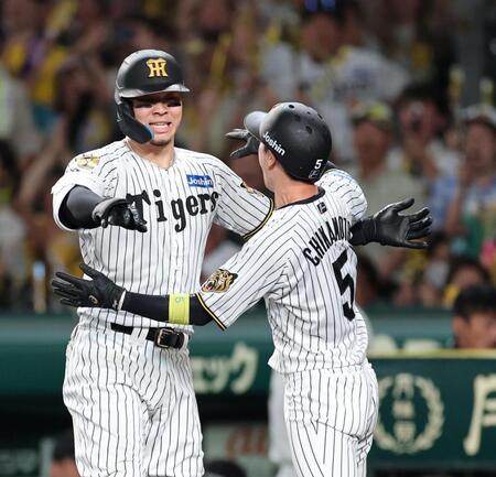 ９回、佐藤輝（左）は生還した近本を迎える（撮影・山口登）