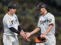 ７回、長岡を一ゴロに仕留め大山（左）とタッチをする伊藤将（撮影・西田忠信）