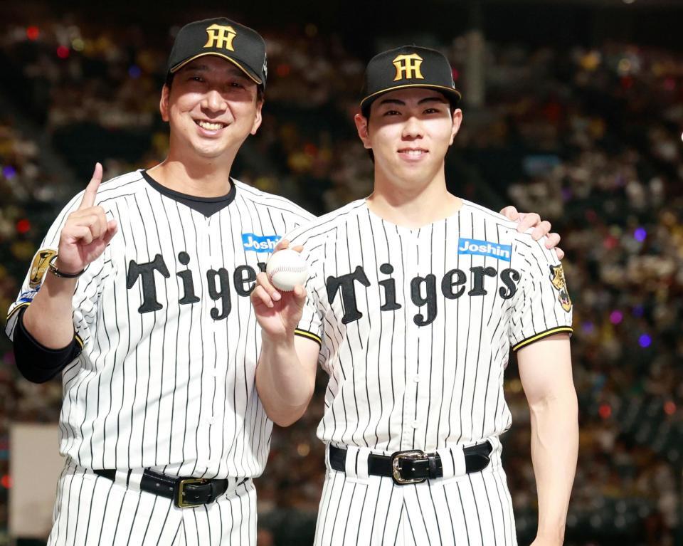 プロ初勝利を挙げ、藤川監督（左）と記念撮影をする工藤（撮影・西田忠信）