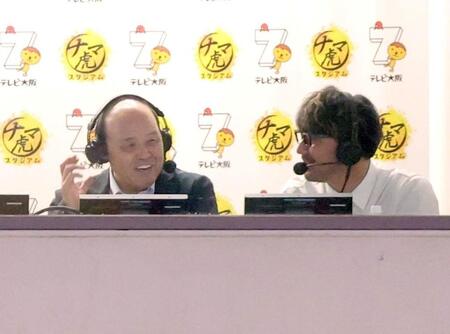 実況席からゲームを観戦する岡田オーナー付顧問（左）＝撮影・立川洋一郎