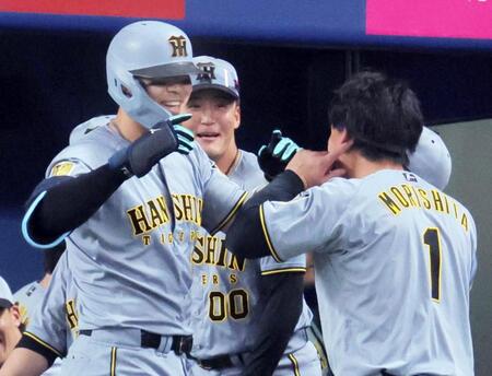 １回、２者連続の本塁打を放ち森下（右）と喜ぶ佐藤輝