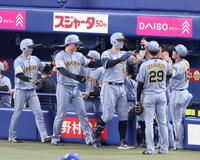 ８回、３ランを放ち出迎えるナインとタッチを交わす佐藤輝（中央）＝撮影・立川洋一郎