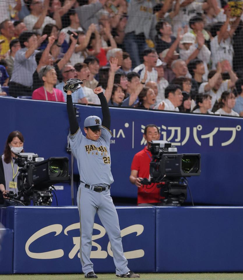 ８回阪神１死一、二塁、阪神・佐藤輝明の３ランに両手を突き上げ喜ぶ阪神・高橋遥人＝バンテリンドーム（撮影・西田忠信）