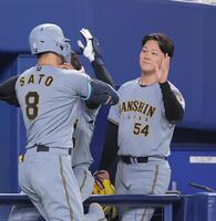 ７回、逆転２ランを放った佐藤輝（左）を迎える木下（撮影・西田忠信）