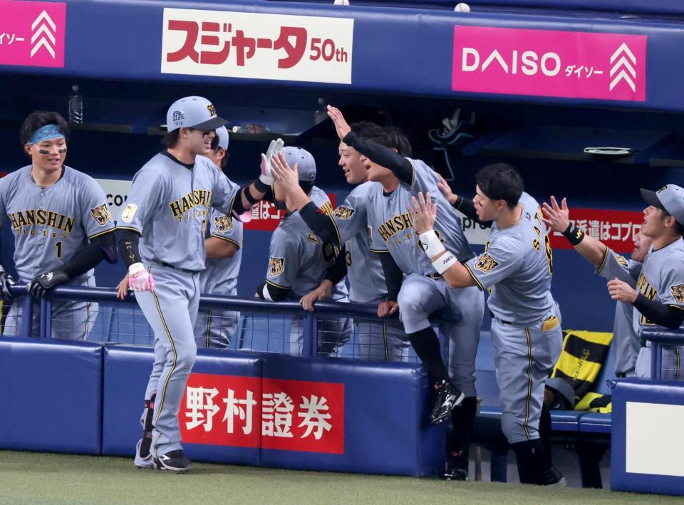 ８回、ソロを放って生還しナインの出迎えに笑顔でタッチを交わす代打・浜田（手前）＝撮影・立川洋一郎
