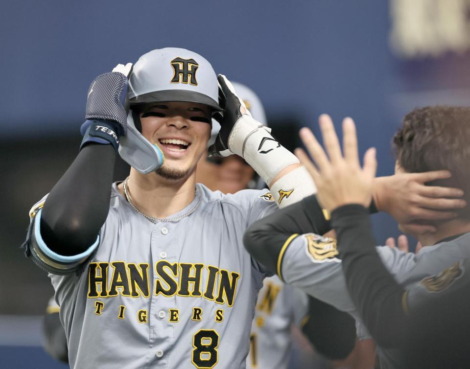 ７回、逆転２ランを放った佐藤輝はナインに迎えられ笑顔を見せる（撮影・田中太一）