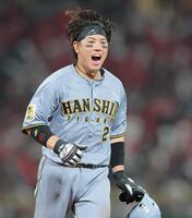 ７回に適時打を放ち笑顔でベンチに戻る梅野（撮影・西田忠信）