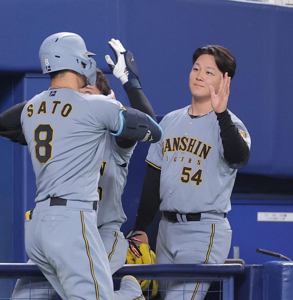 ７回、逆転２ランを放った佐藤輝（左）を迎える木下（撮影・西田忠信）