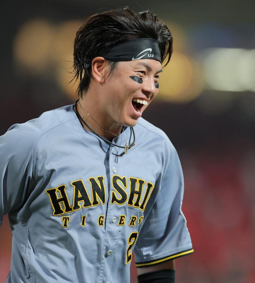 ７回に適時打を放ち笑顔でベンチに戻る梅野（撮影・西田忠信）