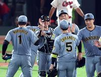 ナインと笑顔でタッチする梅野（中央）＝撮影・山口登
