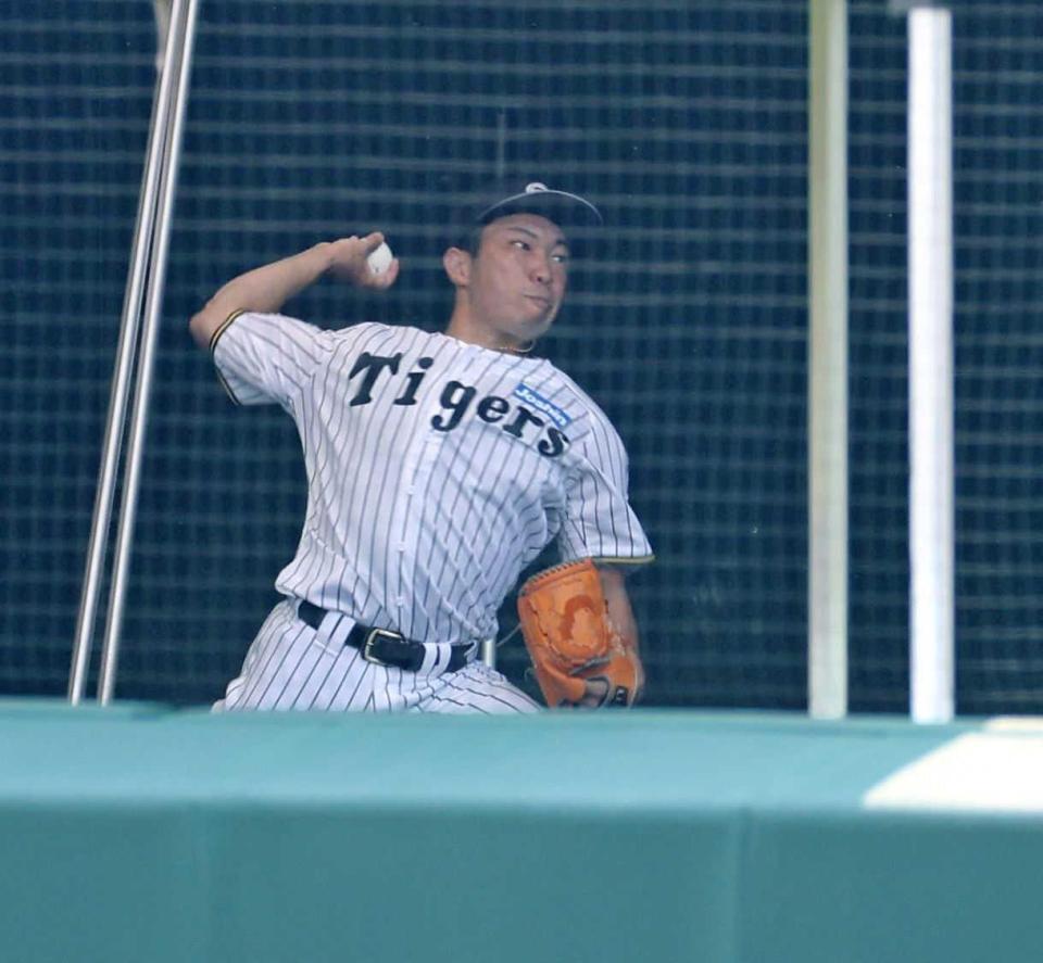 　ブルペンで投球練習する石井