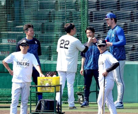 レイノルズ（右）からあいさつを受けタッチを交わす藤川監督。左奥は牧（撮影・立川洋一郎）
