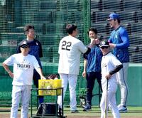 レイノルズ（右）からあいさつを受けタッチを交わす藤川監督。左奥は牧（撮影・立川洋一郎）